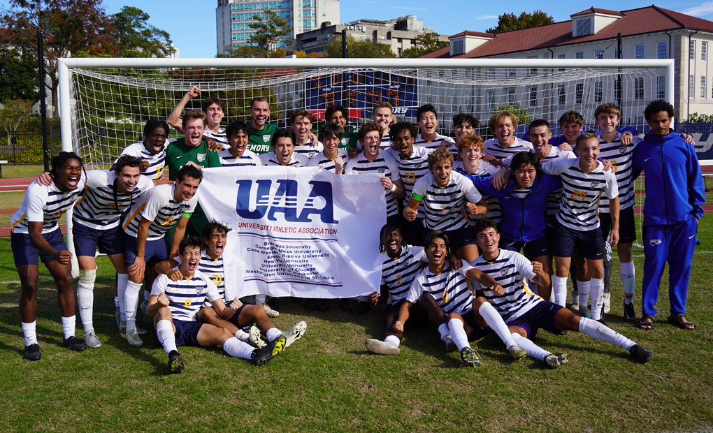 Photo of men's soccer team with championship banner.